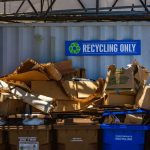 Área de reciclagem com materiais de papelão e papel separados para reaproveitamento.