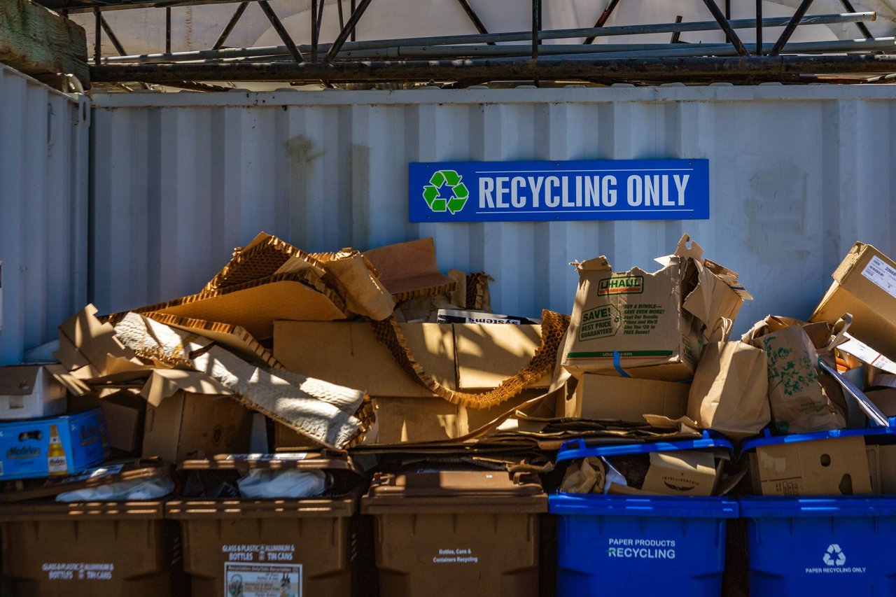 Área de reciclagem com materiais de papelão e papel separados para reaproveitamento.