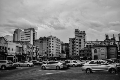 Carros estacionados em uma área urbana de São Paulo, em imagem em preto e branco.