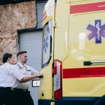 Dois paramédicos fecham as portas traseiras de uma ambulância antes de uma ocorrência.