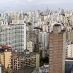 Vista panorâmica de uma área urbana, com edifícios e horizonte sob o céu.
