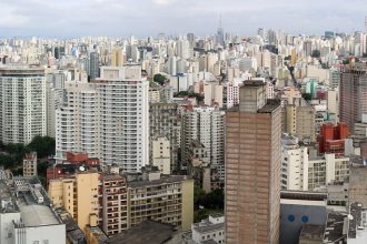 Vista panorâmica de uma área urbana, com edifícios e horizonte sob o céu.