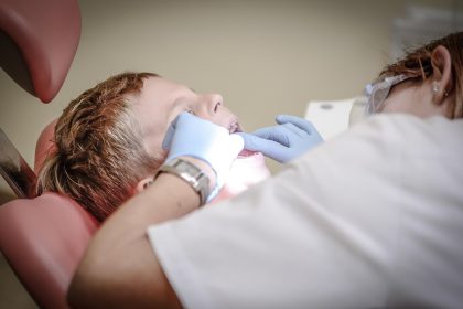 Dentista realiza avaliação odontológica em paciente durante atendimento em clínica.