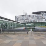 Fachada e entrada de um complexo hospitalar, com área externa arborizada.